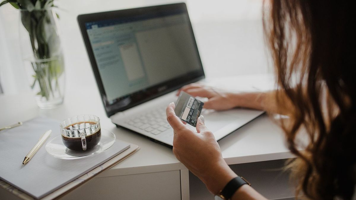 Persona che acquista online con carta di credito davanti a un portatile